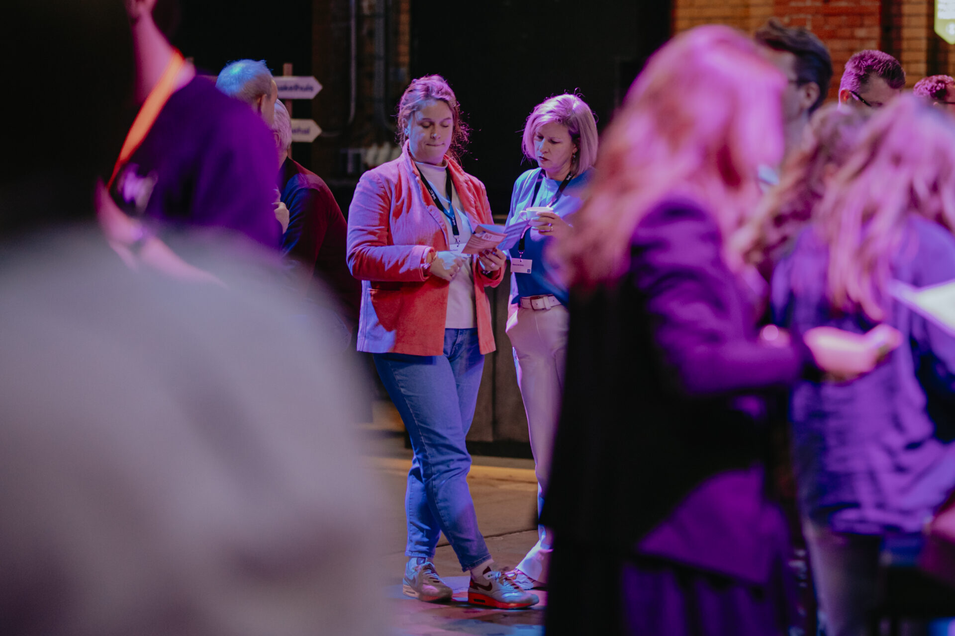 Twee bezoekers bekijken samen het programmaboekje van Media van Morgen