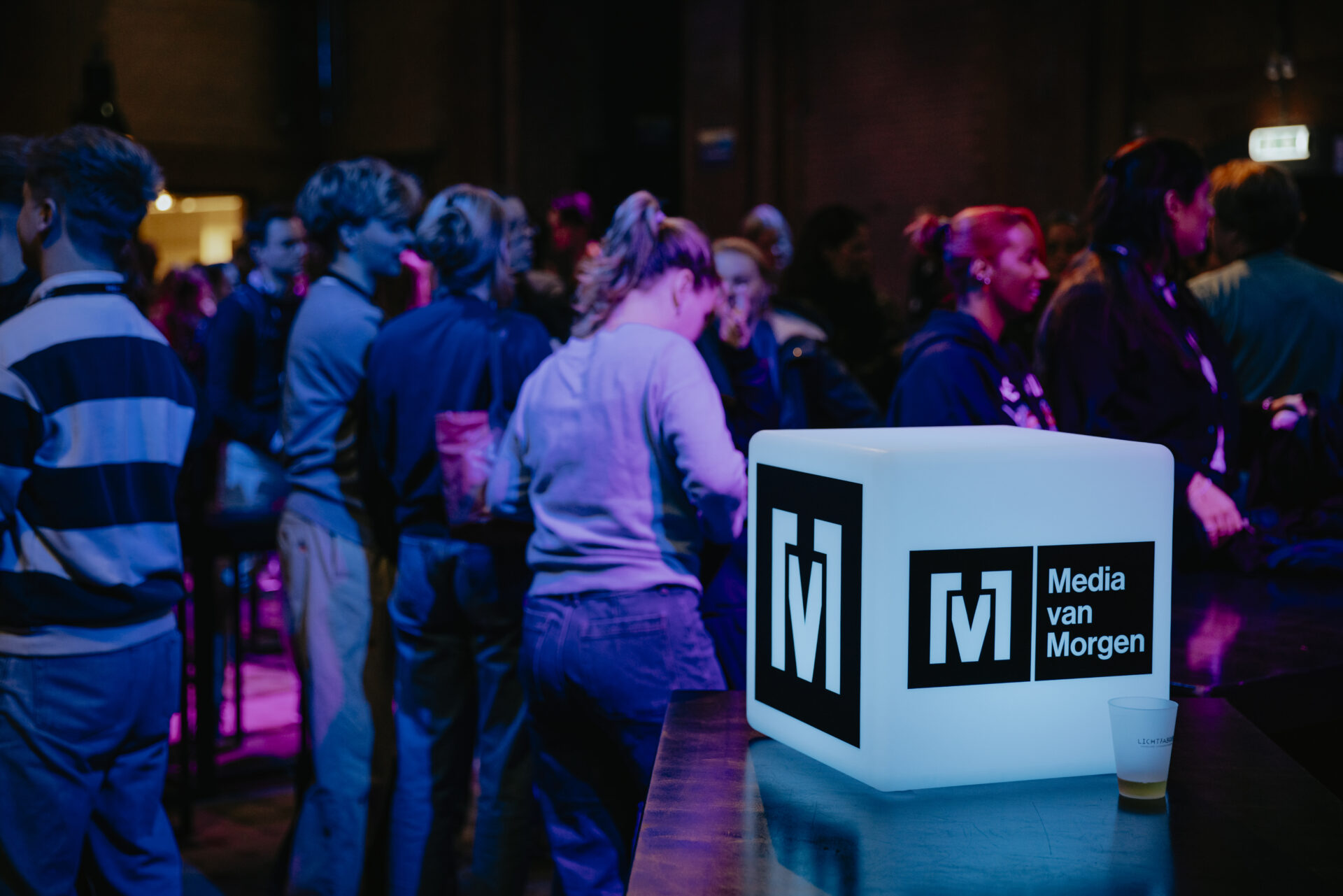 Een groep bezoekers met op de voorgrond een led-kubus met het logo van Media van Morgen
