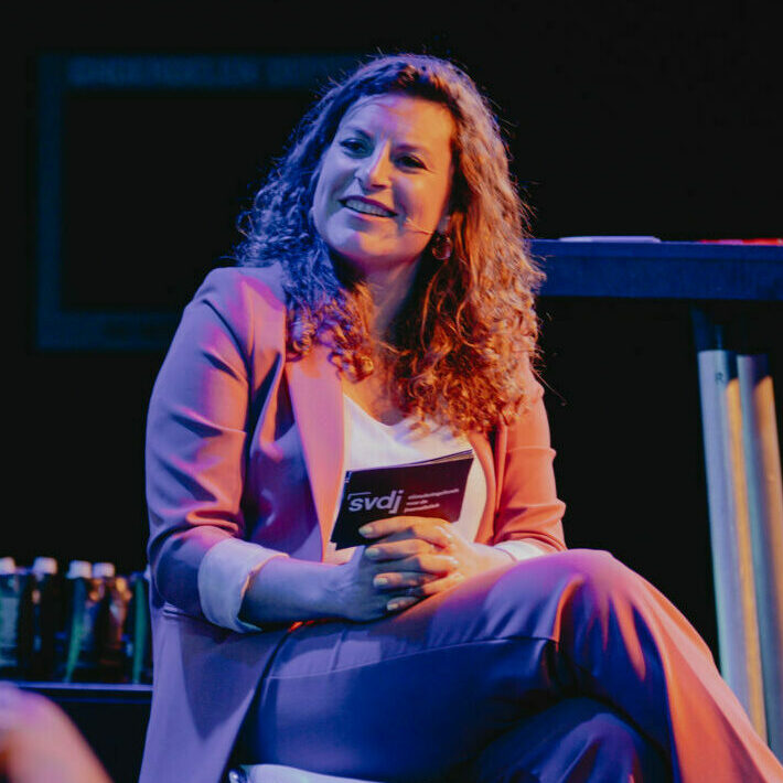 Portret Suse van Kleef, met paars en roze lichten op een podium
