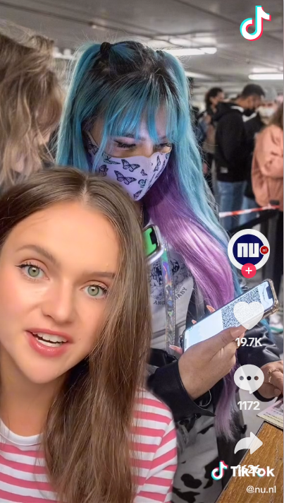 Screenshot van een TikTok video van NU.nl. Een vrouw in een gestreept shirt (presentator) voor een afbeelding van een coronacheck met QR-code. De afbeelding linkt door naar de TikTok video. 